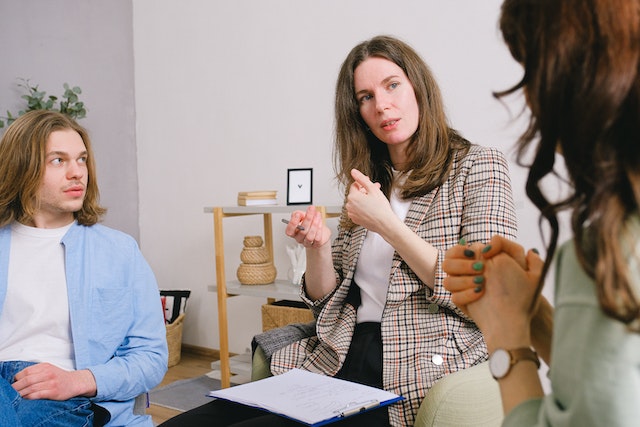 three people sitting in a half circle having a conversation